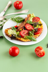 Golden omelette with salad mix and spicy aroma on top