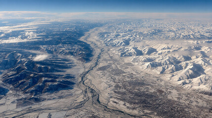 Aerial view of glacial terrain with soft light refraction on icy surfaces showcasing frozen landscape textures and patterns creating a serene arctic atmosphere and natural winter environment