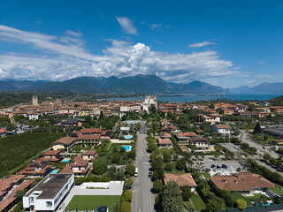 Garda Lake's Historic Town: A high-angle drone shot of Manerba del Garda, showcasing its historic site and charming Italian village on the tranquil shores of Garda Lake. A beautiful landscape.