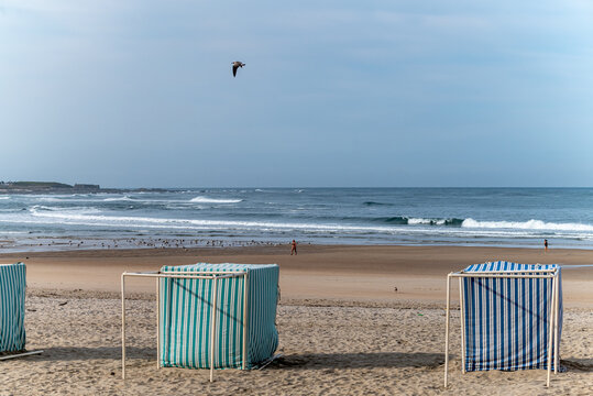 A beautiful beach in Portugal with traditional striped tents, Beach Vacation