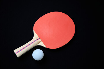 table tennis racket and ball on black background