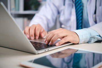Medical doctor working on laptop in hospital patient records and communicate via telehealth, technology medicine, data security, and modern care. concept telehealth productivity