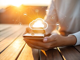 Person holding a smartphone with a glowing cloud icon and network connections overlaid symbolizing cloud computing and digital connectivity during a warm sunset