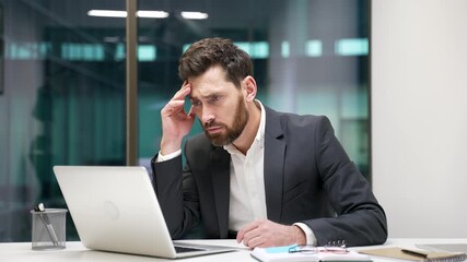 Frustrated businessman having difficulty making transaction using laptop while sitting at workplace in business office. Confused male worker in a formal suit having problems working online on computer - Powered by Adobe