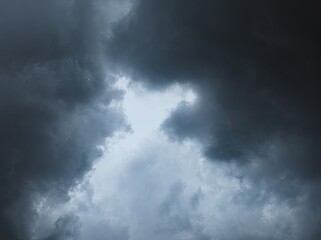 Overcast sky with grey and white clouds, indicating heavy rain