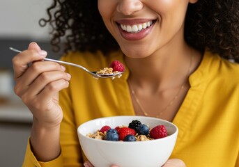 Smiling woman eating breakfast with fruit and cereal