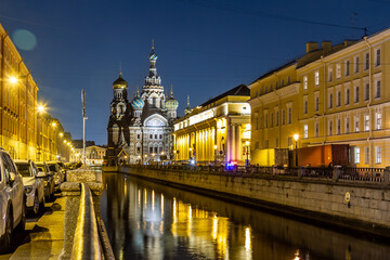 Obraz premium Night perspective view of Griboyedov Canal with illuminated Savior on Spilled Blood church reflection in water. Classic Saint Petersburg atmosphere. Saint Petersburg, Russia 