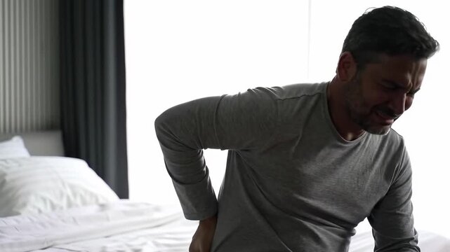 Man in pain, sitting in bedroom