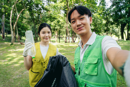 Young volunteers collect plastic bottles cleaning park promoting environmental sustainability community service for a greener world