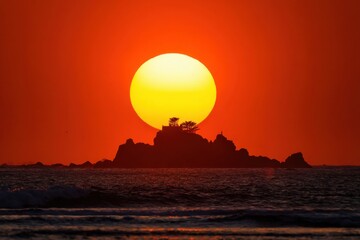 Obraz premium Fiery sunset over a rocky island