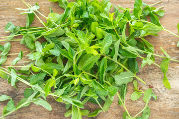 Fresh mint leaves on wooden background. © Iryna