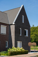 Modern brick home with landscaped yard. Sharp lines and angles define this architectural design on a clear day.