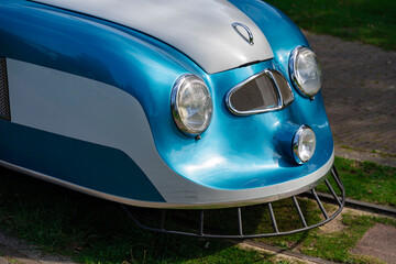 Vintage train front detail: Blue, white, silver. Curved lines and shiny lights on display. Retro transport.