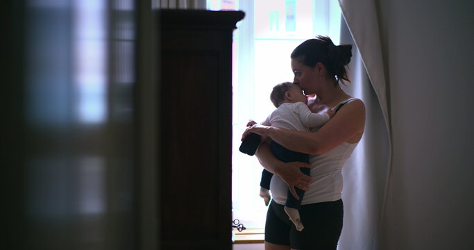 Mother holding her baby in a softly lit room, cradling the infant in a peaceful, nurturing moment of caregiving and connection, showcasing love and calmness-SD 480p