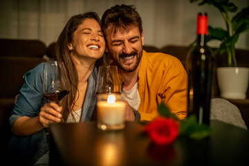 Couple enjoys romantic evening with wine and laughter at home