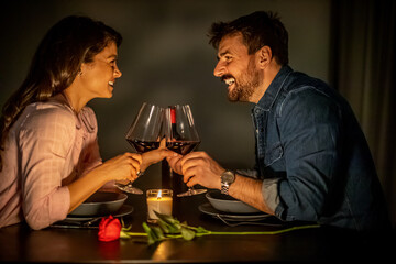 Romantic dinner with wine, candles, and a rose for a couple celebrating a special evening indoors