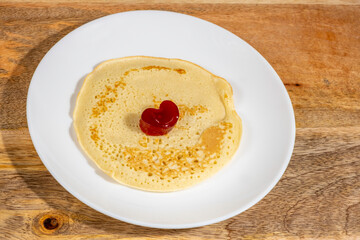Pancake or crepe served with jam for Butter Week on ceramic plate.
