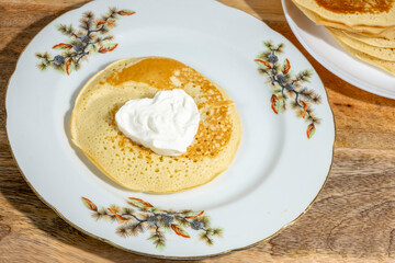 Pancake served with sour cream on ceramic plate for Butter Week.