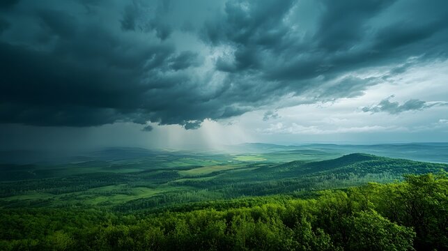 Dramatic Stormy Sky Over Lush Green Rolling Hills and Forests clouds rain photo