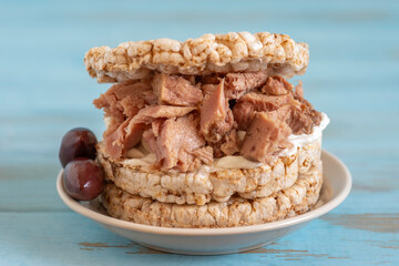 Sandwich made of rice cakes, tuna, tahini salad, pickled olives.
