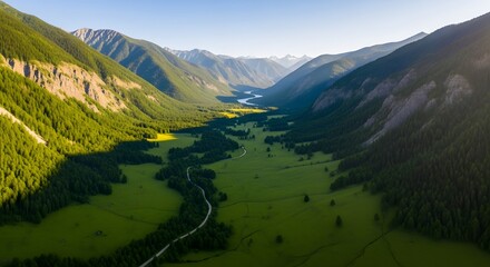 Photo of an aerial view of a lush green valley surrounded by majestic mountains under a clear blue sky