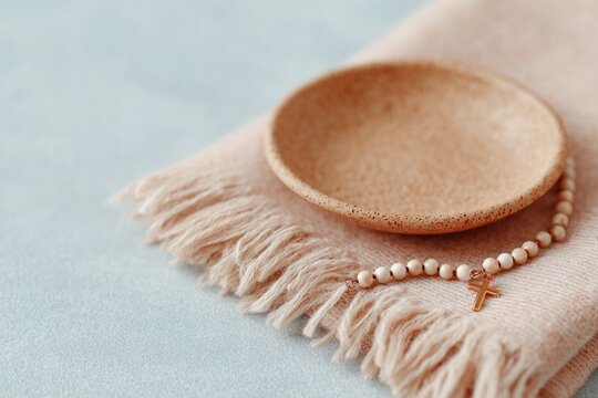 Simple round dish rests on soft fabric, accented by delicate bea