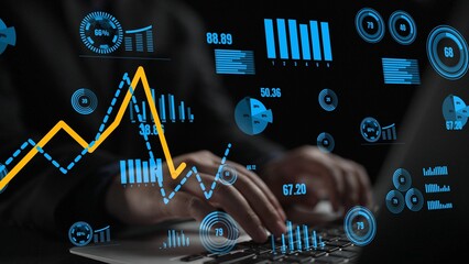 A businessman engages in data analysis on a laptop, surrounded by graphs and charts. The dark...