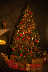 Christmas tree decorated with red and gold ornaments and lights. Festive interior for winter holiday celebration and New Year.