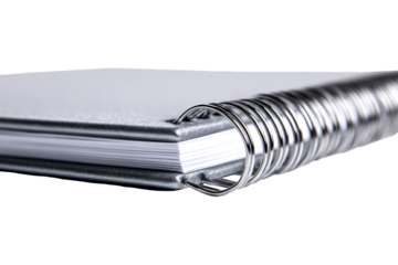 Close-up of a spiral-bound notebook.  White pages, gray cover, and metal spiral binding are visible.  The notebook is angled, showcasing the binding