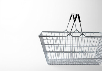 An empty metal shopping basket. Space for text.