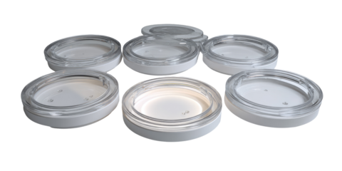 Several round, white plastic containers with clear lids.  Small, round, light-colored holes are visible on the base of each