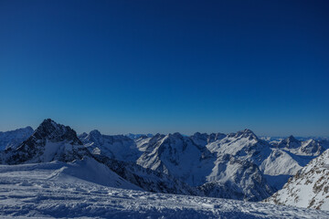 Obraz premium Stunning snowy peaky mountain range with bright blue sky above