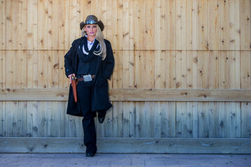 Western Boldness: Blonde Cowgirl Poses with Revolver in Rugged Southwestern Desert