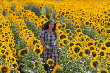 Young brunette smiling in sunflower row