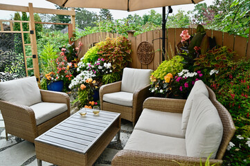 Outdoor seasonal backyard luxurious flagstone patio with cozy seating and tropical gardens and flowering planters