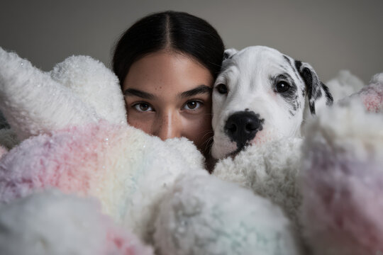 young girl and her playful puppy are hiding under table engaged in magical game in whimsical toy world