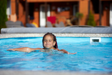 Obraz premium Girl enjoying a playful swim in the pool