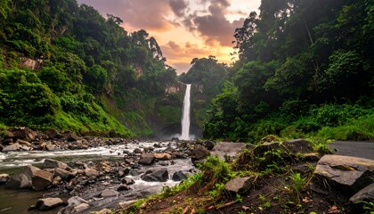 Lush waterfall cascading down a rocky ravine at sunset