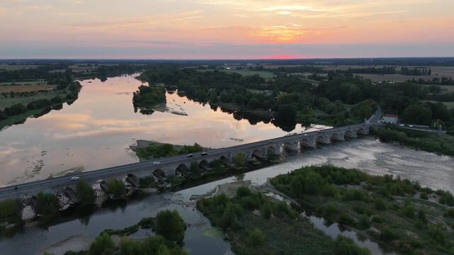 Lever de soleil sur le pont de Beaugency qui traverse la Loire. Travelling en avant au-dessus du pont. 