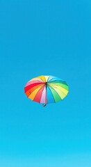 Colorful umbrella floats in the blue sky