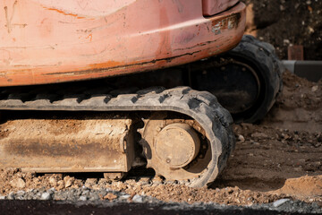 Close-up of excavator crawler track on dirt ground at construction site, highlighting industrial equipment, building machinery, and infrastructure development with heavy vehicles