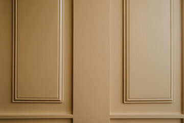 Warm light on panel wall. Beige decorative panels with classic molding. Interior background for architecture and design themes.