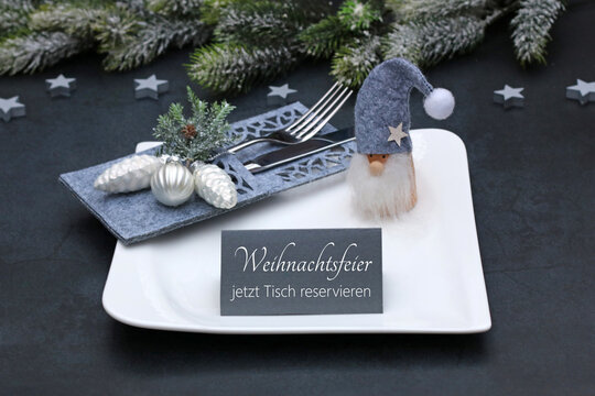 Weihnachten Reservierung: Gedeckter Tisch mit Teller, Besteck, Weihnachtsdekoration und einer Tischkarte mit der Beschriftung Weihnachtsfeier jetzt Tisch reservieren.	 - Powered by Adobe