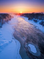 Naklejka premium A stunning winter sunrise casts colorful hues over a misty river. Steam rises from the water, while snow blankets the surrounding landscape, creating a serene atmosphere