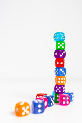 Colorful dice tower on white background with scattered dice below