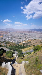 Panoramic view of Sanandaj city from Abidar heights, showcasing urban sprawl amid mountain ranges...