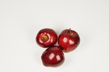 Group of red apples on a table in close-up with copy space under a white background