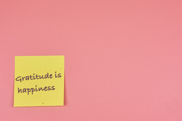 Sticky note with thank you word in foreground with copy space on pink background