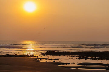 Golden sunset casting warm light over the calm waves of the Cox’s Bazar sea.