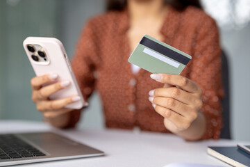 Woman using smartphone and credit card for online shopping